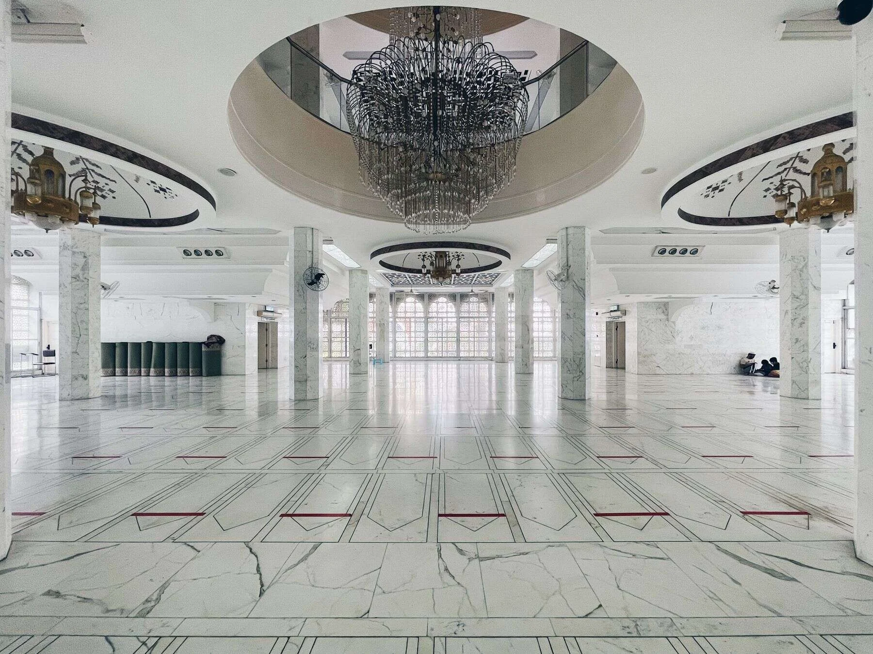 Large hall with a white marble floor and chandelier