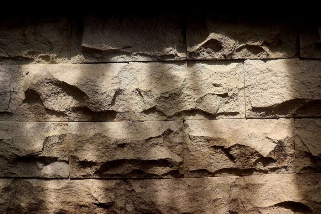 Rough sandstone wall face in warm light