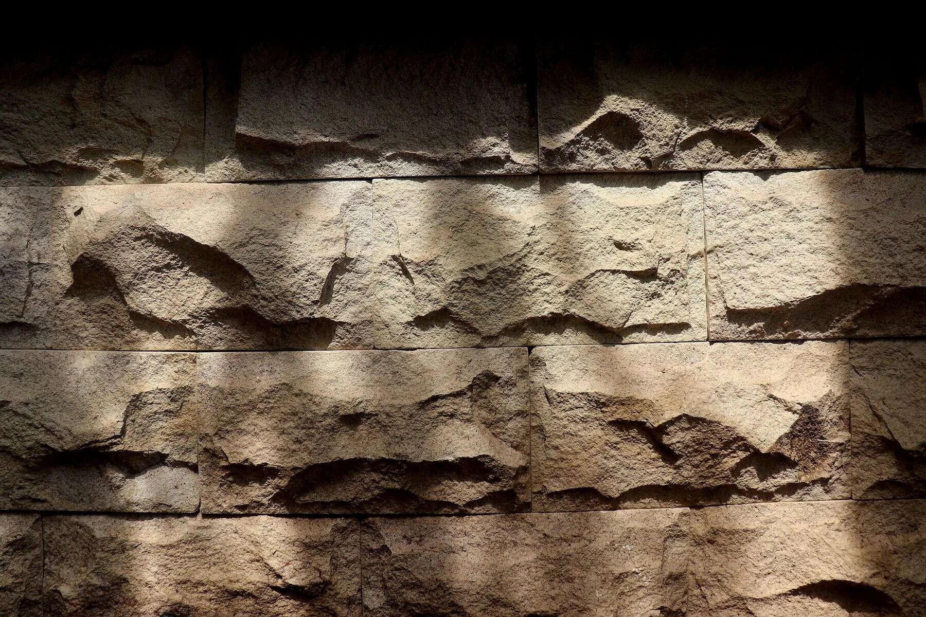Rough sandstone wall face in warm light