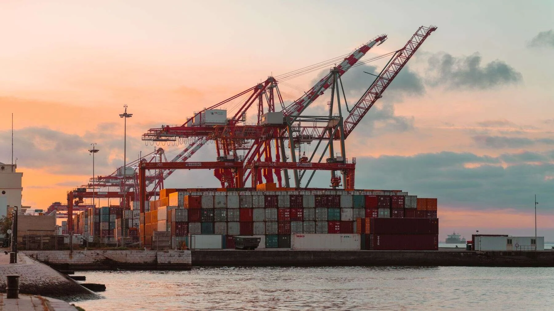 Port cranes and containers at sunset