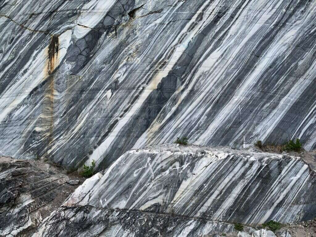 Natural marble quarry wall with flowing grey and white veins
