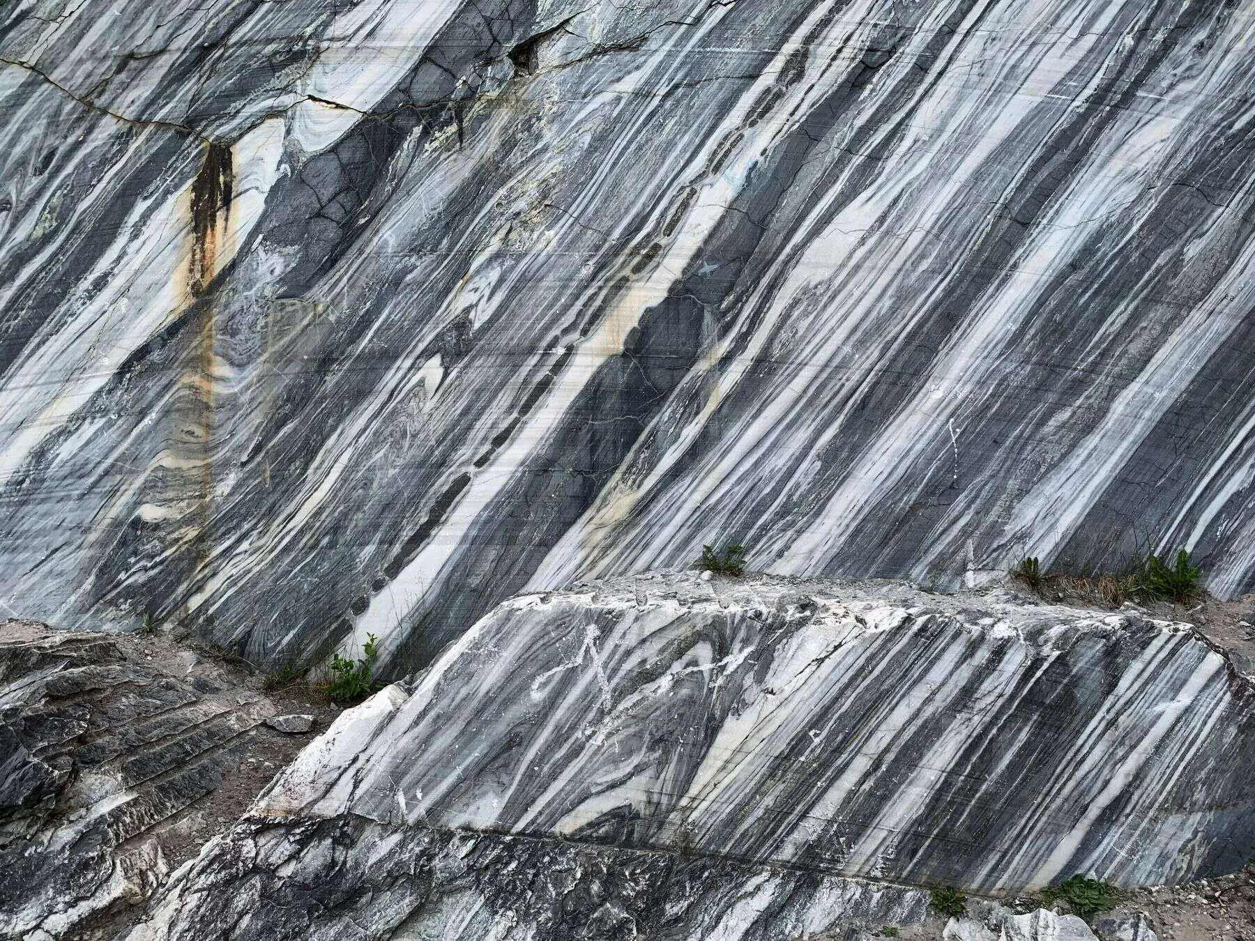 Natural marble quarry wall with flowing grey and white veins