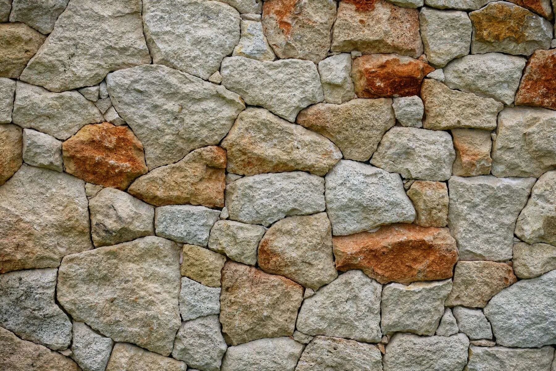 Natural sandstone rock wall in warm cream and orange tones