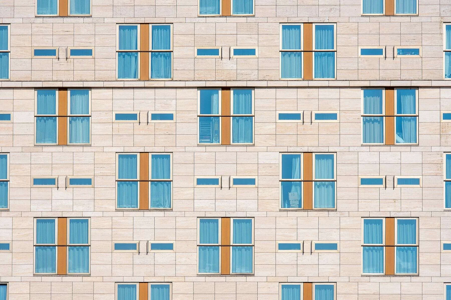 Hotel facade clad in light natural stone panels