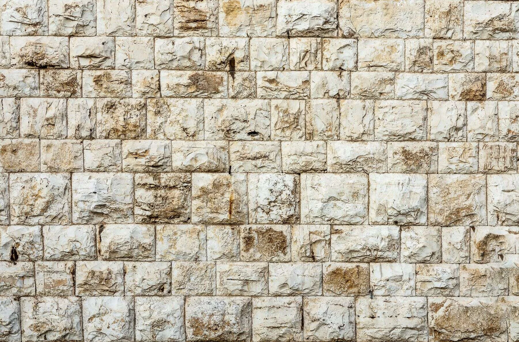 Cream and brown limestone block wall