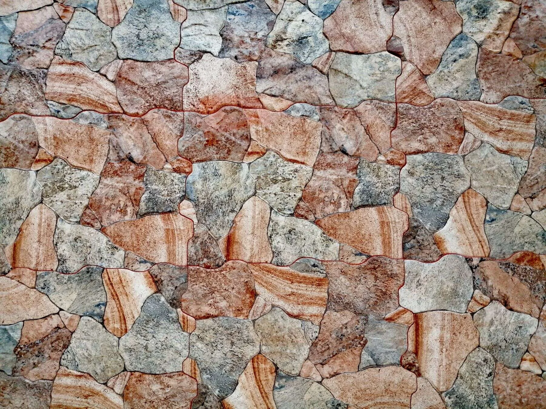 Natural stone wall with orange and grey quartzite pieces