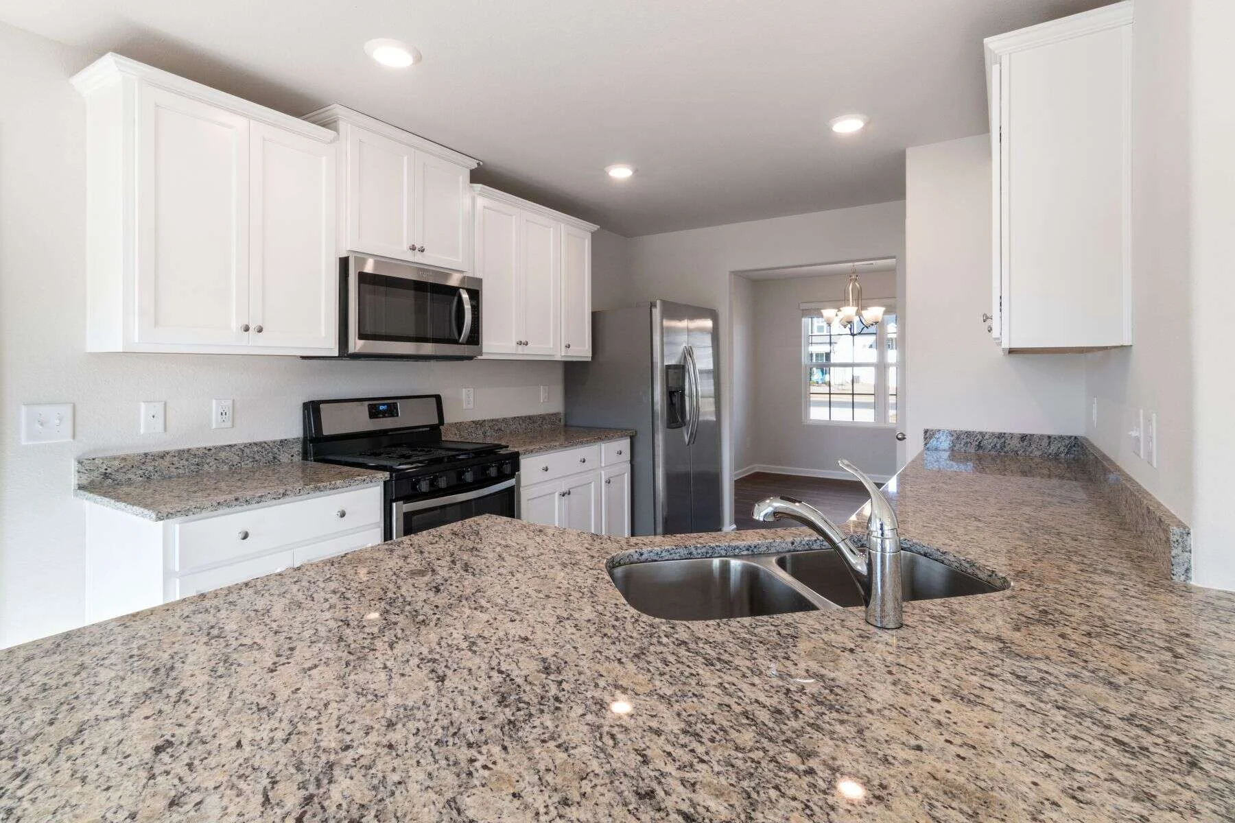 Bright kitchen with white cabinets and a granite countertop