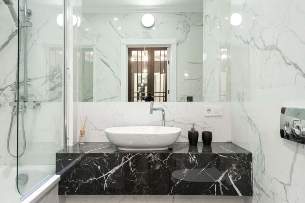 Bathroom with black marble vanity and white marble walls