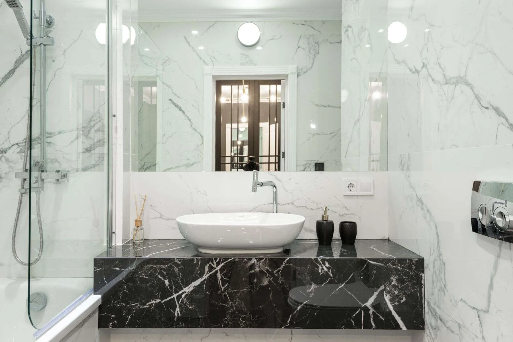 Bathroom with black marble vanity and white marble walls