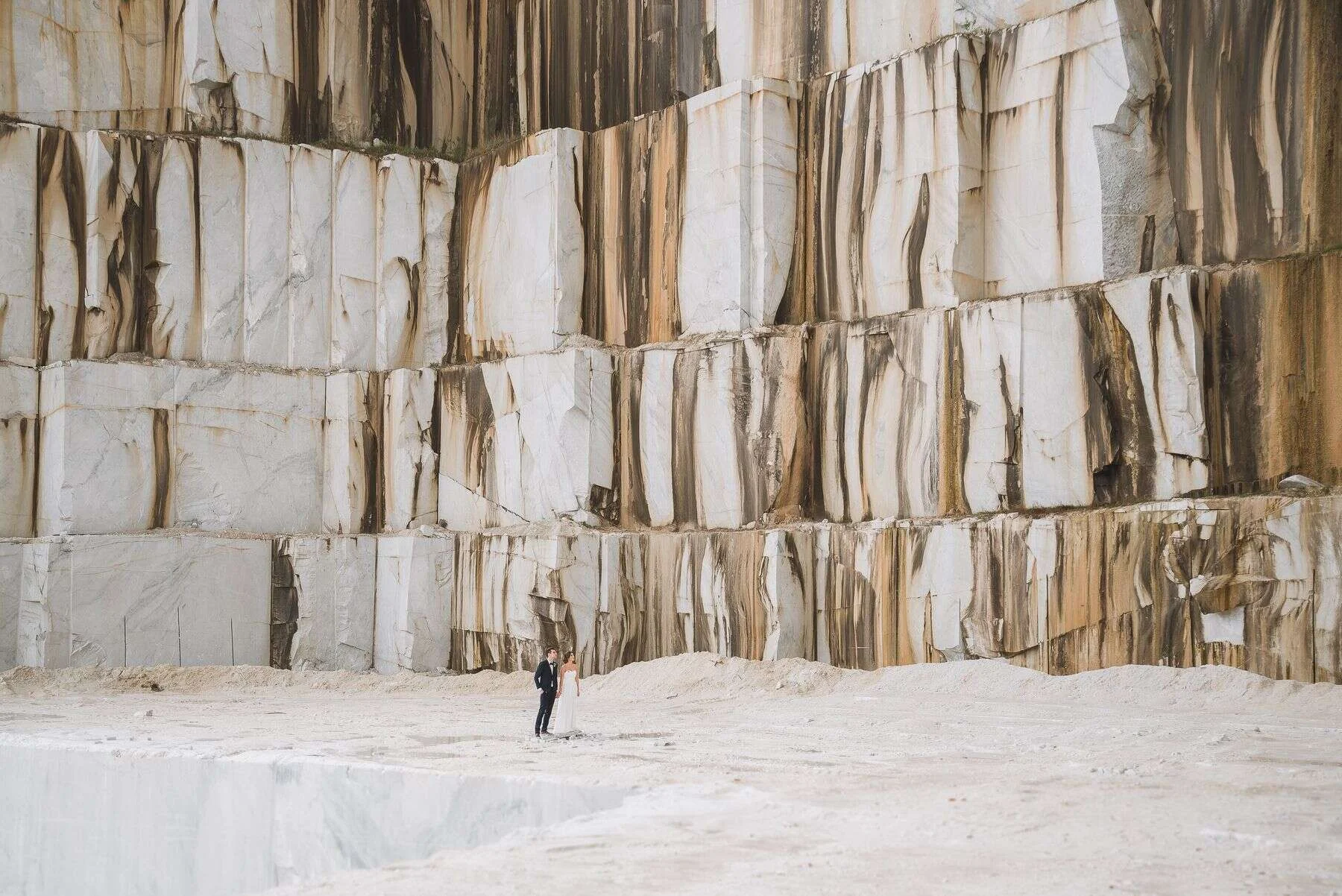 Tall white marble quarry wall with brown veining