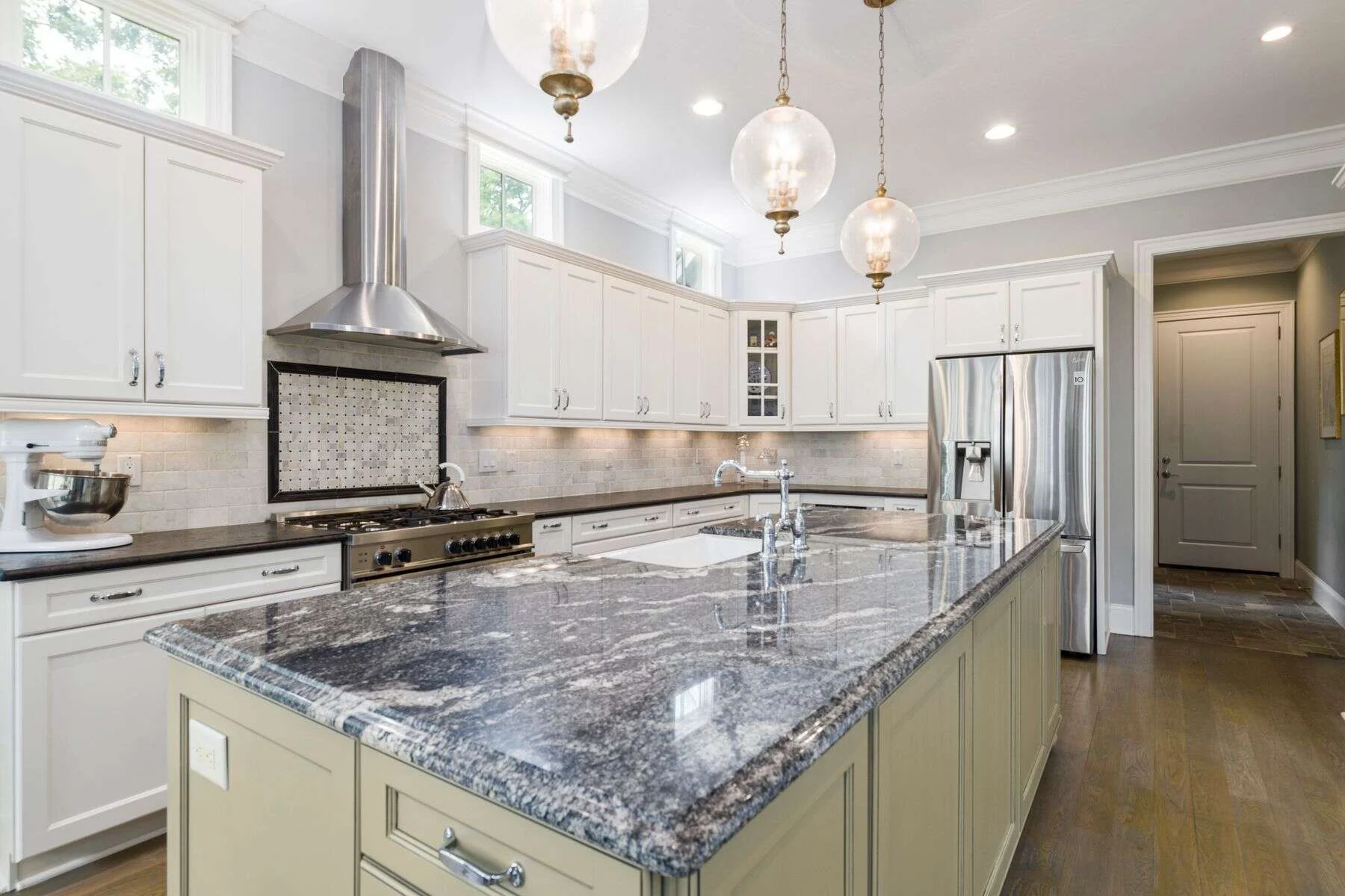 Dark granite kitchen island in a white kitchen